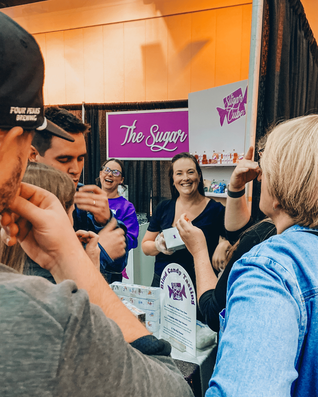 Guests gathered around an interactive Blind Candy Tasting booth at a live event