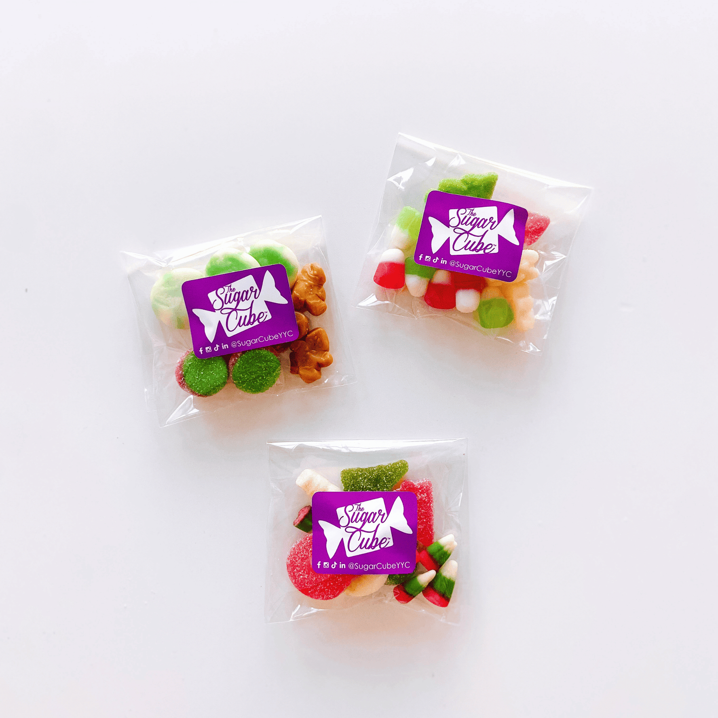 Three Christmas candy bags featuring festive red, green and white candy mixes for holiday gifting