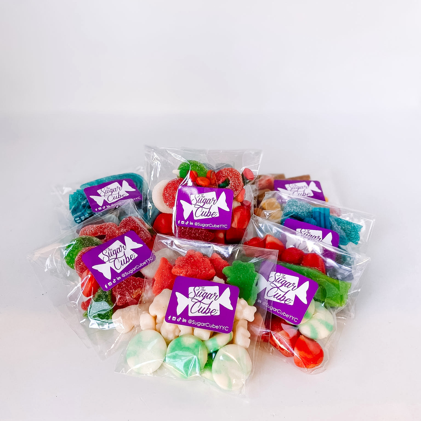 Colourful holiday candy bags piled together featuring five festive Christmas candy mixes
